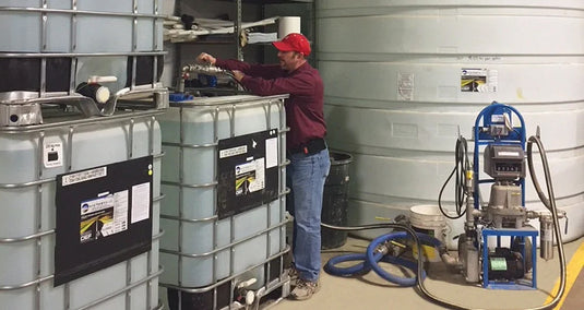 Man Standing Next to Bulk Storage Tanks